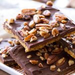 This Pumpkin Spice Cracker Toffee recipe is full of sweet spices and rich chocolate! This easy homemade toffee begins with graham crackers, making this toffee recipe a cinch to make! Homemade toffee is the perfect fall dessert or Thanksgiving dessert! Plus, a video of the step-by-step process below!