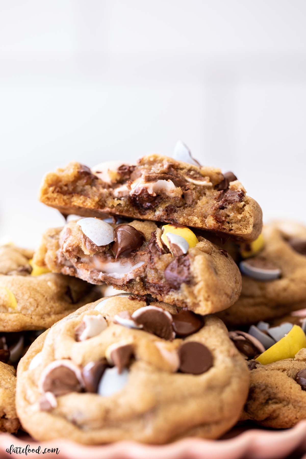 Cadbury Egg Chocolate Chip Cookie in half with gooey cadbury creme egg filling melting out the center.