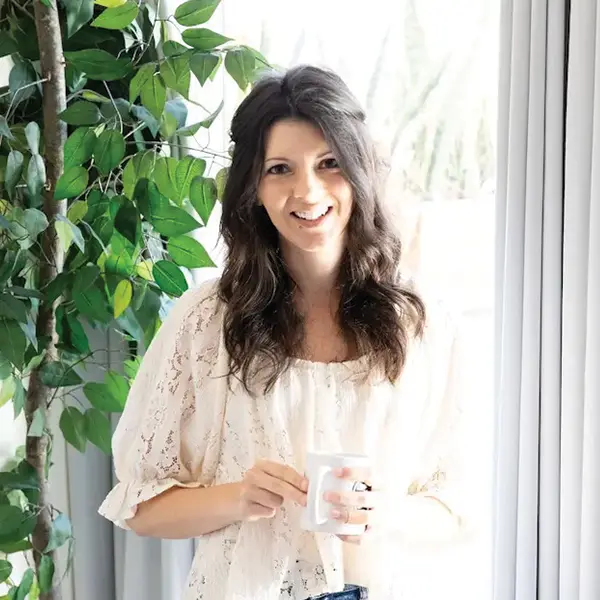 Michelle, author of A Latte Food, sitting in front of window smiling.